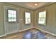 Bright living area featuring wood-look floors, neutral paint, and lake views from large windows at 139 Sanford Ln, Badin Lake, NC 28127