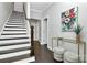 Inviting entryway with hardwood floors, staircase, console table with decor, and an artistic floral painting at 1412 W 4Th St, Charlotte, NC 28208