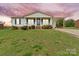 Charming one-story home with a covered porch and carport set on a well-manicured lawn under a dramatic sky at 1504 Andicot Ln, Shelby, NC 28152