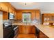 Well-lit kitchen featuring classic wood cabinetry, stainless steel appliances, and a decorative tile backsplash at 1504 Andicot Ln, Shelby, NC 28152