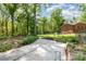 Spacious backyard with a concrete patio, mature trees, and chain link fence at 1565 Oakridge Dr, Salisbury, NC 28146