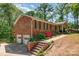 Brick house featuring a two-car garage, side deck, and landscaped yard with colorful azalea bushes at 1565 Oakridge Dr, Salisbury, NC 28146