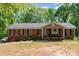 Charming brick home featuring a well-manicured lawn and an inviting front porch, perfect for relaxing at 1565 Oakridge Dr, Salisbury, NC 28146
