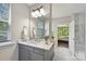 This bathroom features marble floors, a gray vanity with modern fixtures, and an ensuite door to the bedroom at 16518 Here At Last Ln, Charlotte, NC 28278