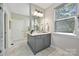 This bathroom features marble floors, a gray vanity with double sinks, modern fixtures, and a window at 16518 Here At Last Ln, Charlotte, NC 28278