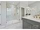 The bathroom has marble floors, a glass shower, a gray vanity, and modern brass fixtures at 16518 Here At Last Ln, Charlotte, NC 28278