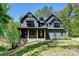 Beautiful two-story home featuring dark blue siding and wooden accents on its gable roof and front porch at 16518 Here At Last Ln, Charlotte, NC 28278