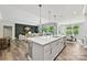 Open kitchen concept with a large island, sink, and view into a Gathering room and dining area at 16518 Here At Last Ln, Charlotte, NC 28278