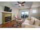 Inviting living room with a fireplace, stylish decor, and balcony access at 18723 Vineyard Point Ln, Cornelius, NC 28031
