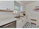 Bright kitchen featuring stainless steel appliances, white cabinetry, marble countertops and blue and white tile flooring at 216 Wakefield Dr # B, Charlotte, NC 28209