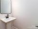 Well-lit bathroom with a pedestal sink, large mirror, and modern fixtures at 2505 Elon St, Charlotte, NC 28208