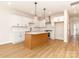 Bright kitchen features white cabinets, an island, stainless appliances, and hardwood floors at 2505 Elon St, Charlotte, NC 28208