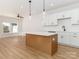 Bright kitchen features white cabinets, an island, stainless appliances, and hardwood floors at 2505 Elon St, Charlotte, NC 28208