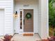 Inviting front entrance with a tan door, classic black lantern, and decorative green wreath at 2507 Elon St, Charlotte, NC 28208