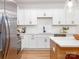 Contemporary kitchen featuring white cabinets, quartz countertops, stainless steel appliances, and herringbone tile backsplash at 2507 Elon St, Charlotte, NC 28208