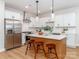 Bright kitchen with stainless steel appliances, white cabinets, herringbone backsplash, and a kitchen island with seating at 2507 Elon St, Charlotte, NC 28208