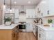 Modern kitchen with white cabinetry, stainless steel appliances, a quartz countertop, and an island with seating at 2507 Elon St, Charlotte, NC 28208