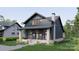 Two-story home with stone accents, a covered porch, and a meticulously landscaped front yard at 2557A Hemphill St, Charlotte, NC 28208