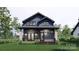 Charming two-story home with stone accents, a covered porch, and a beautifully landscaped front yard at 2557A Hemphill St, Charlotte, NC 28208