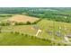 Expansive aerial shot of a home in a verdant setting, featuring multiple outbuildings and a long driveway at 3648 Plainfield Dr, Shelby, NC 28150