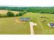 A beautiful aerial view showcases a modern home with a long driveway, surrounded by lush green land and mature trees at 3648 Plainfield Dr, Shelby, NC 28150