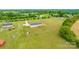 Aerial view of a home featuring a large grassy yard, fenced area and mature trees in a serene country setting at 3648 Plainfield Dr, Shelby, NC 28150