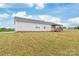 Home's rear exterior features a covered deck, an expansive yard, and mature trees at 3648 Plainfield Dr, Shelby, NC 28150