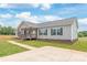 Inviting gray home featuring a cozy covered porch and manicured lawn at 3648 Plainfield Dr, Shelby, NC 28150