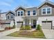 Charming two-story townhome with stone accents, attached garages, and well-manicured lawn under a sunny blue sky at 3813 Amalia Pl, Indian Land, SC 29707