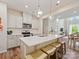 Open-concept kitchen with island seating, pendant lights, and views of the dining and living areas at 3813 Amalia Pl, Indian Land, SC 29707