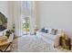 Bright living room with high ceilings, white couch, area rug, and sliding door to backyard at 3813 Amalia Pl, Indian Land, SC 29707