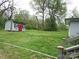 Spacious backyard featuring mature trees and a convenient shed with red trim, offering ample storage or workspace at 412 E Broad St, Salisbury, NC 28144