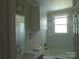 Bright bathroom featuring a single sink vanity, bathtub and shower combination, and a window at 412 E Broad St, Salisbury, NC 28144