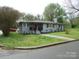 Charming single-story home featuring a red front door, gray brick, and landscaped yard with mature trees at 412 E Broad St, Salisbury, NC 28144