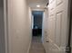 Hallway leading to a bedroom, featuring a white door and light-colored wood flooring at 412 E Broad St, Salisbury, NC 28144