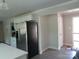 Open-concept kitchen with stainless steel refrigerator, white cabinets, and views to the front door at 412 E Broad St, Salisbury, NC 28144