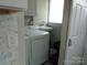 Convenient laundry area with washing machine, dryer, utility sink, and storage shelves at 412 E Broad St, Salisbury, NC 28144