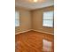 A bright bedroom with laminate floors, two windows, and neutral wall paint at 415 S Broad St, Gastonia, NC 28052