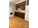 Classic kitchen with wooden cabinets, white appliances, and laminate wood floors at 415 S Broad St, Gastonia, NC 28052
