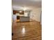 Open living space with laminate wood floors and a kitchen area in the background at 415 S Broad St, Gastonia, NC 28052