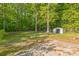 The backyard has a lot of tall trees, grass, a storage shed, and a concrete pad at 4336 Valeview Ln, Charlotte, NC 28269