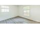 Bright bedroom features modern gray floors and two windows, with neutral paint at 4336 Valeview Ln, Charlotte, NC 28269