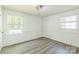 This bedroom features light-colored walls, wood-look floors, and two windows for ample light at 4336 Valeview Ln, Charlotte, NC 28269