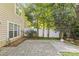 Backyard featuring a stone patio, grassy areas, and mature trees providing shade at 4418 Coventry Row Ct, Charlotte, NC 28270
