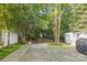 Backyard features a stone patio and green space, surrounded by lush trees at 4418 Coventry Row Ct, Charlotte, NC 28270