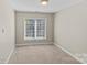 Neutral bedroom with light-colored carpet and natural light from the window at 4418 Coventry Row Ct, Charlotte, NC 28270