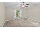 Bright bedroom with neutral carpet, ceiling fan, and a window with natural light at 4418 Coventry Row Ct, Charlotte, NC 28270