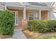 Inviting front porch with brick columns and manicured green bushes at 4418 Coventry Row Ct, Charlotte, NC 28270