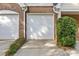 Attached garage with two doors and brick facade, offering ample parking and storage at 4418 Coventry Row Ct, Charlotte, NC 28270