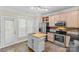 Well-lit kitchen features stainless steel appliances, a center island, and tile floors at 4418 Coventry Row Ct, Charlotte, NC 28270